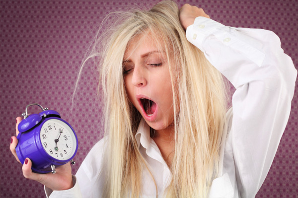 tired-woman-with-alarm-clock